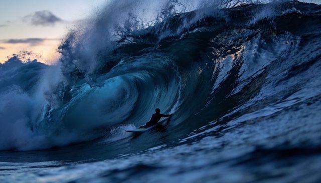 Surfer Crouching Inside Massive Sunset Barrel Wave Riding Shortboard Silhouette Ocean Action