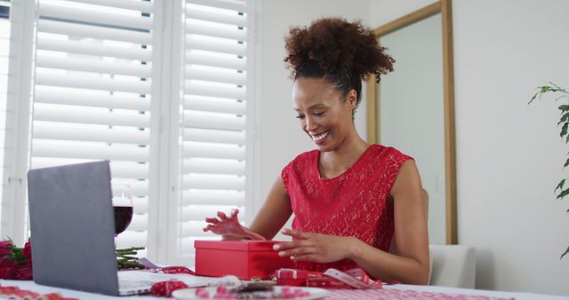 Happy biracial woman on a valentines date image call, opening gift - Download Free Stock Photos Pikwizard.com