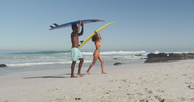 Young Man and Woman Carrying Surfboards on Sandy Beach - Download Free Stock Images Pikwizard.com