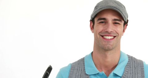 Smiling young golfer standing against white background with copy space