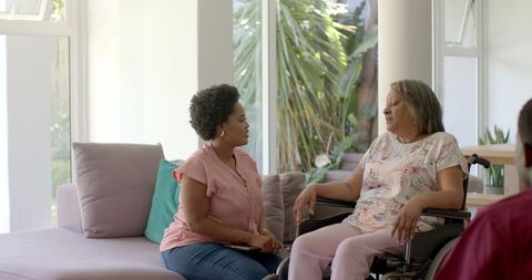 Senior Friends Conversing in Bright Living Room