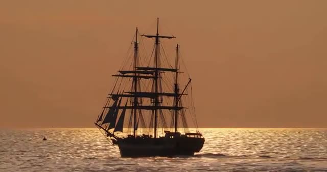 Sailing Ship at Sunset in Tranquil Sea Waters