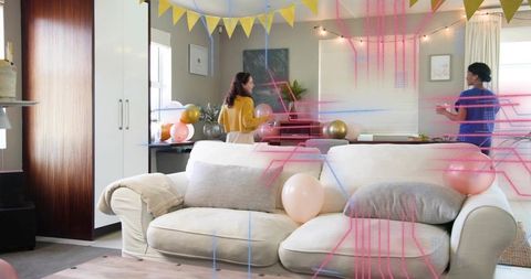 Women decorating living room for casual pastel party with balloons and banners