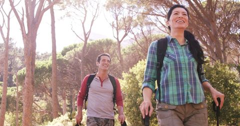 Happy Couple Hiking Through Lush Forest on Sunny Day