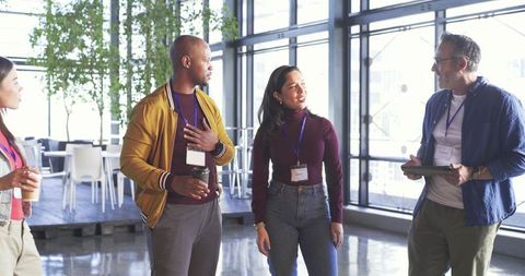 Multicultural professionals networking in modern office lounge during conference break