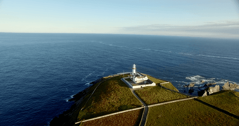 transparent lush hill and lighthouse overlooking vast sea - Download Free Stock Videos Pikwizard.com