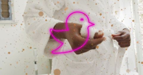 Woman tying bathrobe belt with neon bird reflection