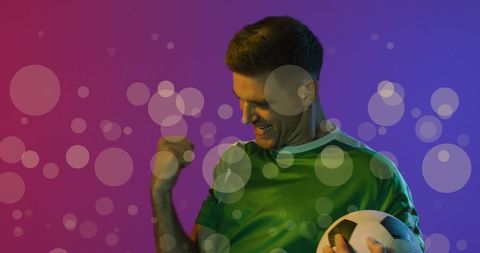 Ecstatic soccer player in colorful abstract bokeh spotlight