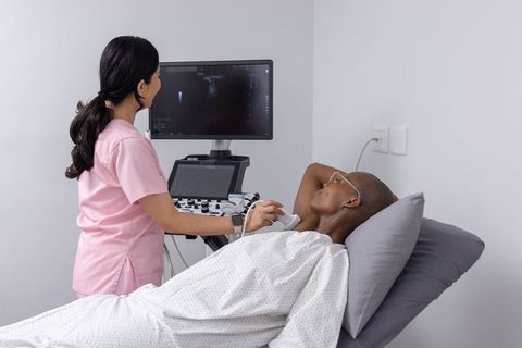 Clinician performing neck ultrasound on patient using portable sonography machine