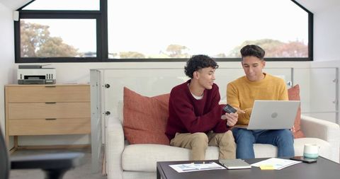 Friends Collaborating on Financial Analysis at Home with Laptop