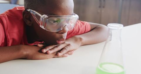 Curious Child Observing Green Liquid Experiment at Home
