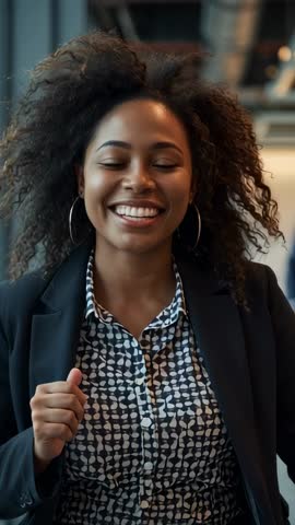 Smiling professional woman walking toward camera in modern office corridor, vertical video