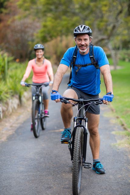 Smiling athletic couple cycling on the road