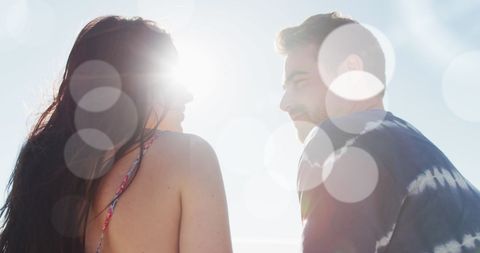 Romantic Couple Enjoying Sunny Day with Lens Flare Effect on Beach