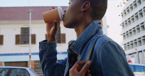 Young Woman Enjoying Coffee Break Outdoors in Cityscape