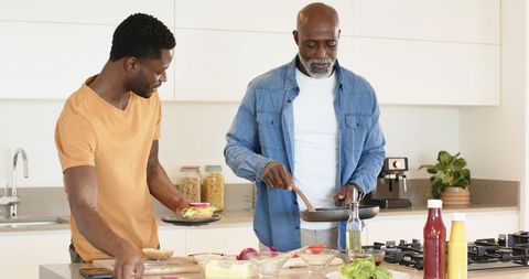 Father and Son Cooking Together in Modern Kitchen Interior