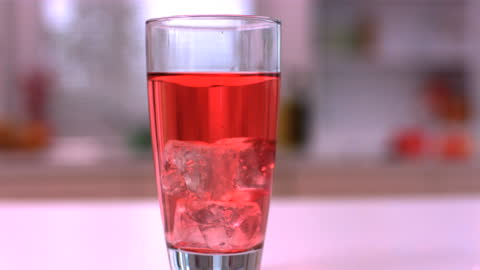 Refreshing Red Juice with Ice Cubes in Glass on Table