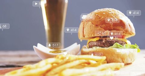Cheeseburger with sesame bun and crispy fries featuring social media notifications overlay