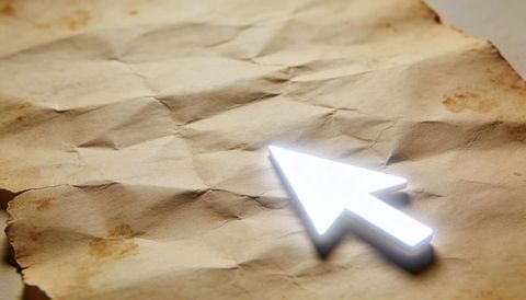 Glowing cursor arrow hovering over wrinkled parchment casting digital glow on vintage paper