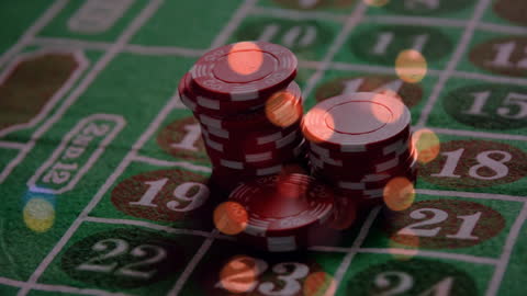 Poker Chips Stack on Roulette Table Background with Light Bokeh