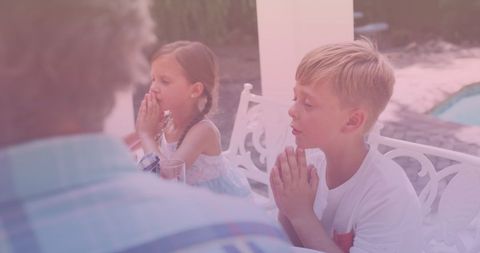 Family Praying Before Dinner Outdoors