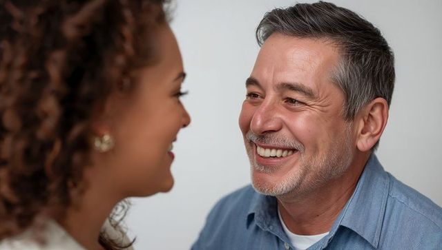 Warm portrait of smiling mature man making eye contact with partner, soft lighting