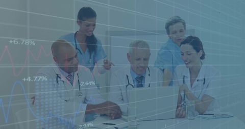 Diverse medical team analyzing data charts on laptop in hospital