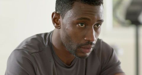 African american man sweating and focusing on cardio training, intense gym close-up