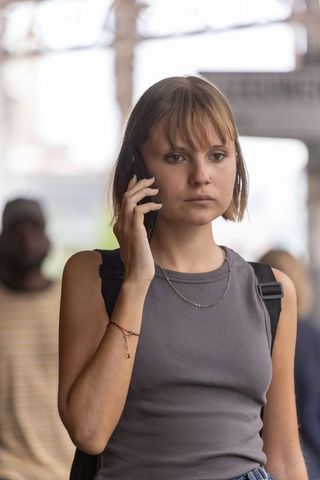Young woman talking on smartphone on transit platform, urban commute, city lifestyle