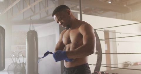 Focused boxer preparing with hand wraps in boxing gym