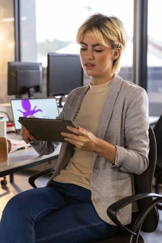 Professional woman engaging with tablet in contemporary office workspace