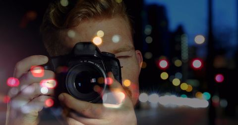 Photographer Capturing Night City Lights with Camera