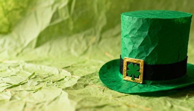 Green Leprechaun Top Hat with Gold Shamrock Buckle on Crinkled Paper Background Editorial