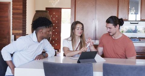 Diverse Team Discussing Ideas Using Tablet at Home