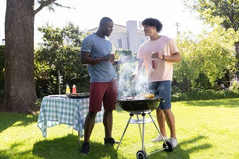 Two Friends Enjoying Backyard Barbecue on a Sunny Day
