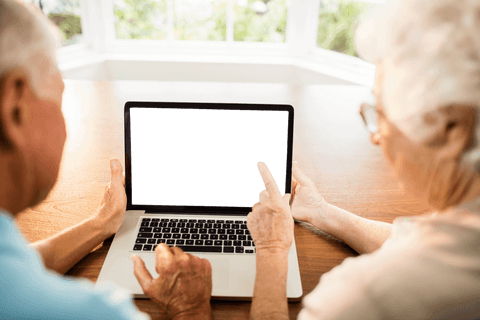 Senior Couple Engaged with Empty Laptop Screen at Home Online Setting