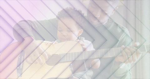 Father teaching baby guitar, guiding hands for early music bonding and family connection