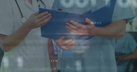 Medical team reviewing blue clipboard and patient chart in clinical collaboration