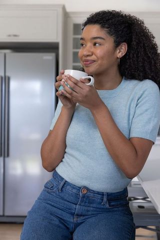 Woman Relaxing in Cozy Kitchen Holding Mug