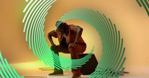 Crouching modern performer in artistic studio environment