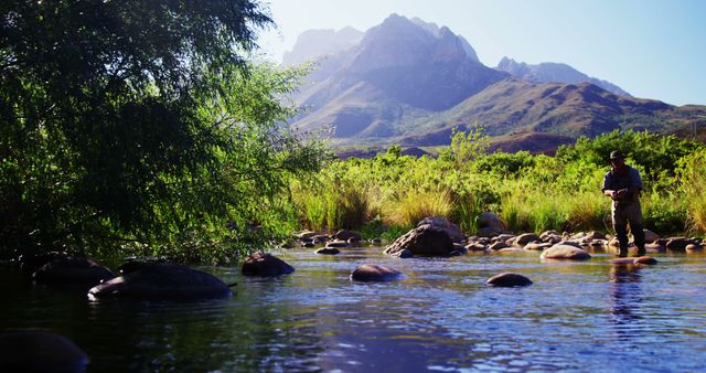 Man Observing Nature at Riverside with Scenic Mountain Backdrop - Download Free Stock Images Pikwizard.com