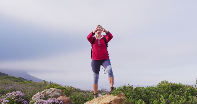 A senior woman embraces adventure with open arms atop a mountain during her hike. - Download Free Stock Photos Pikwizard.com