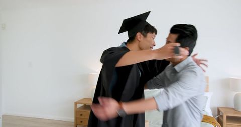 Proud Father Giving Graduation Gift to Smiling Son