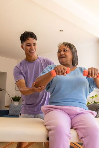 Senior woman exercising at home with personal trainer guidance