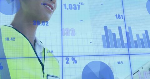 Engineer Monitoring Real-Time Analytics Wall with Tablet and High-Visibility Vest