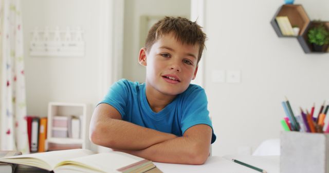 Portrait of caucasian boy with arms crossed smiling looking at the camera at home - Download Free Stock Photos Pikwizard.com