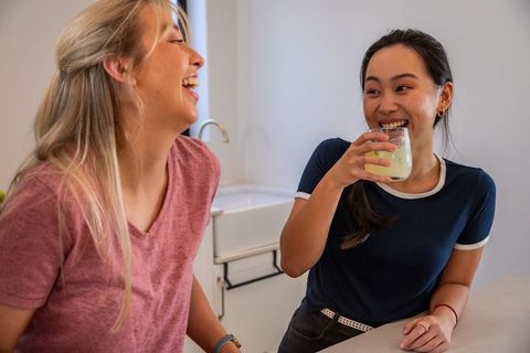 Diverse friends laughing and enjoying refreshing juices together