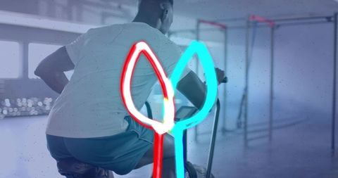 Male athlete pedaling stationary bike with neon light overlay for modern fitness marketing