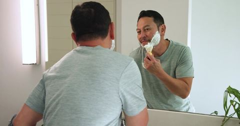 Smiling Man Applying Shaving Cream in Modern Bathroom
