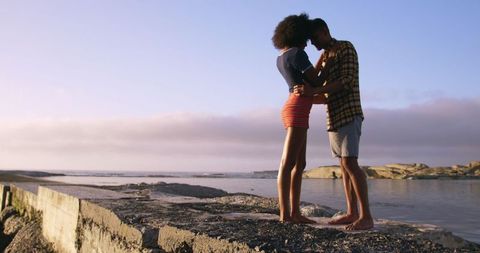 Romantic Young Couple Embracing on Scenic Beach Walkway